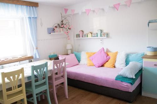a room with a couch with colorful pillows on it at Buntes Bergglück 1923 in Ober-Gossen