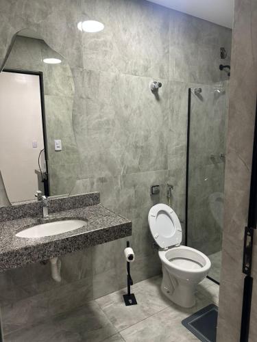 a bathroom with a toilet and a sink and a shower at Henri Karam in Brumadinho