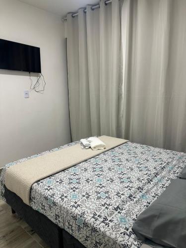 a bedroom with a bed with a blue and white quilt at Henri Karam in Brumadinho