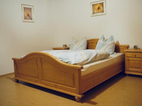 a wooden bed with white sheets and pillows on it at Ferienwohnung Arber in Dösingerried