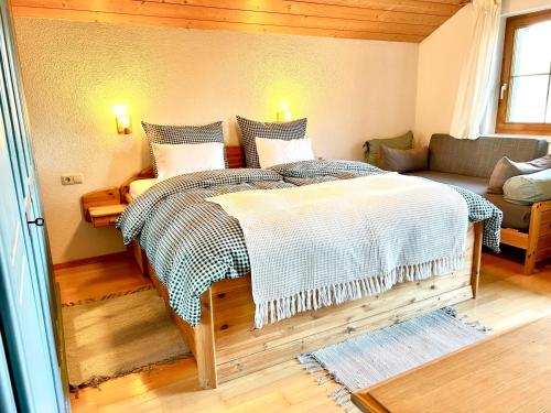 a bedroom with a large bed and a couch at Landhaus Berthold in Bürserberg