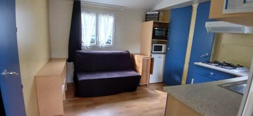 a kitchen with a chair in the middle of a room at camping sous le moulin in Condes