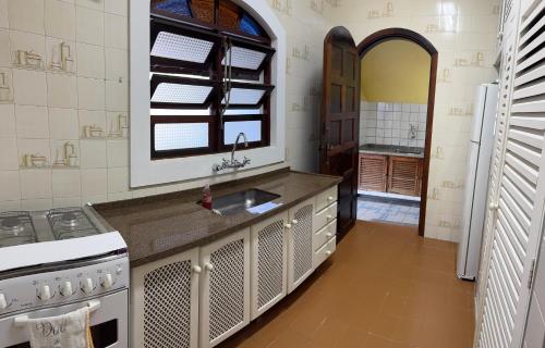 a kitchen with a sink and a stove at Casa Lar Doce Mar Juquehy in São Sebastião