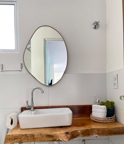 a bathroom with a white sink and a mirror at Casas Carole Maramar Beach House 35 e 36 in Luis Correia