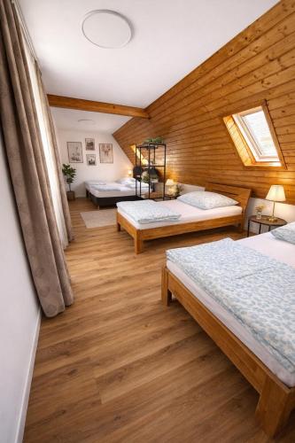 a room with three beds and a wooden wall at Kuzey Apartments in Kappel-Grafenhausen