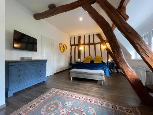 a bedroom with a blue bed and a blue dresser at La Maison Maya Normandie in Saint-Éloi-de-Fourques