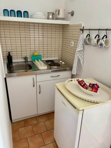 a small kitchen with a sink and a plate on a counter at Apartments Ela in Neum