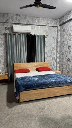 a bedroom with a wooden bed with a ceiling fan at Rsheen Inn in Peshawar