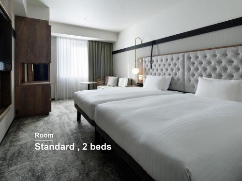 two beds in a hotel room with two beds at Mitsui Garden Hotel Sapporo West in Sapporo