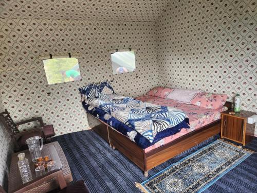 a small bedroom with a bed with a zebra blanket at New Kufari Apple Valley camping in Shimla