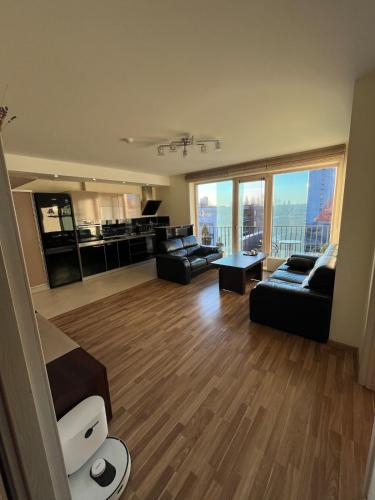 a living room with couches and a large window at Spacious Apartment with 2 Balconies in Klaipėda