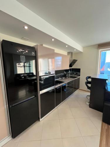 a large kitchen with black cabinets and a counter at Spacious Apartment with 2 Balconies in Klaipėda