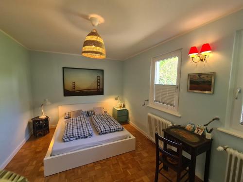 a bedroom with a bed and a table and a window at Gartenchalet Rotkehlchen in Bad Homburg vor der Höhe