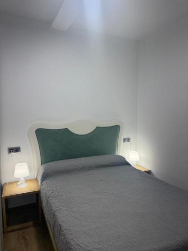 a bedroom with a bed and two lamps on tables at Dalia Somhome in Peniscola
