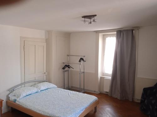 ein Schlafzimmer mit einem Bett und einem Fenster in der Unterkunft Chambre D in Biel