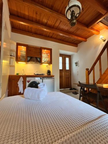 a bedroom with a large bed and a kitchen at HYDRA Central House in Hydra