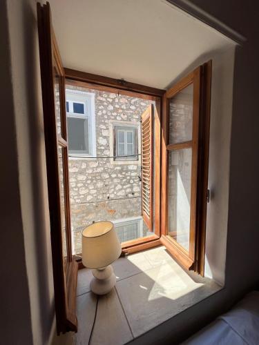 a small window in a room with a table and a stool at HYDRA Central House in Hydra