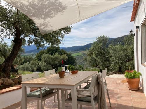 a table and chairs on a patio with a view at Casa del Sueño - Casitas met uitzicht in Alora
