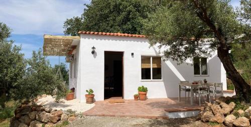 a small white house with a table in front of it at Casa del Sueño - Casitas met uitzicht in Alora