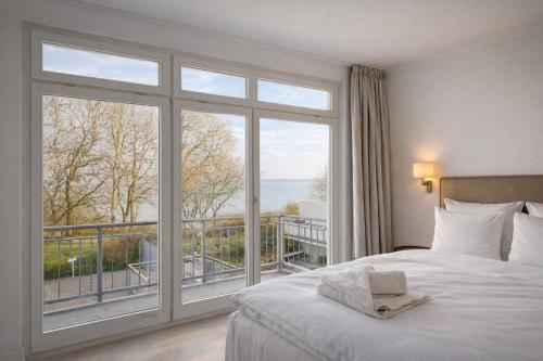 a bedroom with a bed and a large window at Oceanview Residences Lauterbach Rügen Ostsee erste Reihe in Putbus