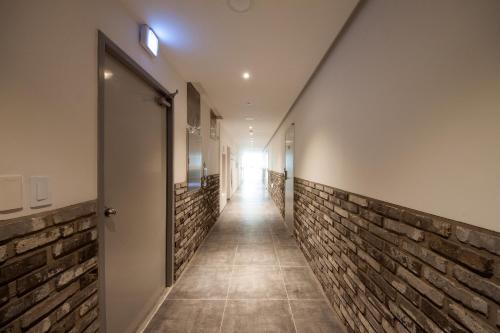 a hallway of a building with brick walls and a door at K-Guesthouse Premium Nampo 1 in Busan