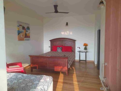 a bedroom with a bed with red pillows on it at Wonderville Ensuite Rooms in Cuncolim
