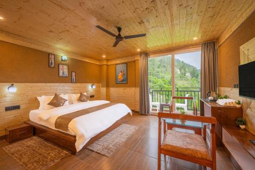 a bedroom with a large bed and a balcony at The Charvi Regency l Multi Cuisine Restaurant l Conference Hall l Scenic Venues for Private Parties l Basic First Aid l Spacious Car Parking l Managed By ExoticStays Group in Shimla