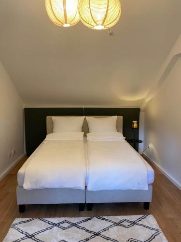 a bedroom with a large bed with white sheets at Halleluja mit Burgblick in Hellenthal