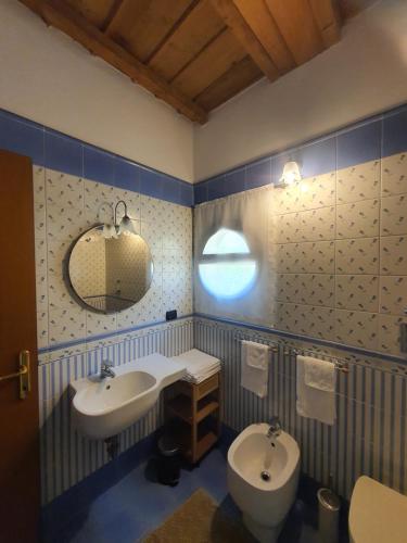 a bathroom with two sinks and a toilet and a mirror at Collina del Milanese in San Colombano al Lambro