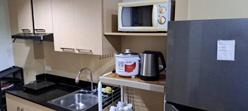 a small kitchen with a sink and a microwave at Brenthill Condo Quartz unit in Baguio