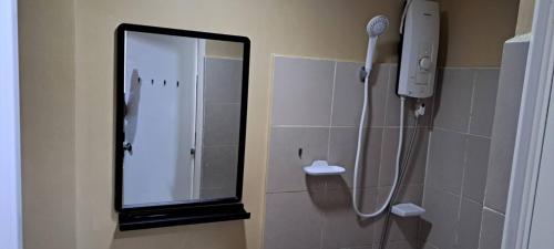 a shower in a bathroom with a mirror at Brenthill Condo Quartz unit in Baguio