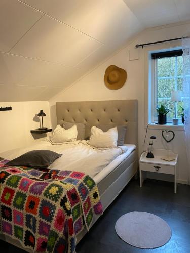 a bedroom with a large bed and a window at Lugnet på landet! in Töllsjö