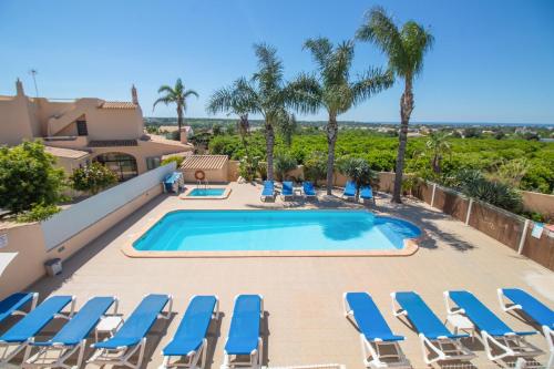 a villa with a swimming pool and lounge chairs at Casa Laranjal in Albufeira