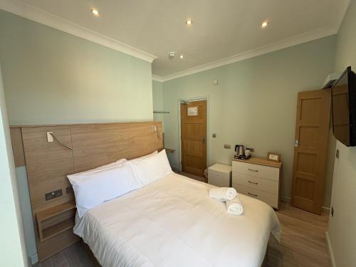 a bedroom with a white bed with a wooden headboard at Hamilton House, Chester in Hope