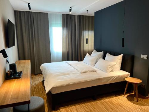 a bedroom with a bed with white sheets and pillows at Green Nights Hotel in Dettelbach