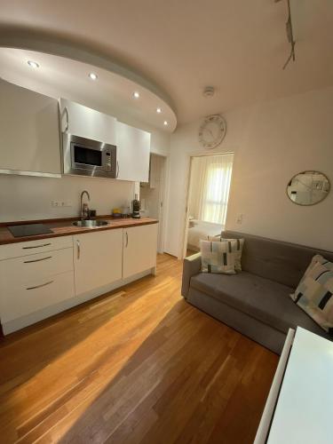 a living room with a couch and a kitchen at Moderne Wohnung - ULM Stadtmitte in Ulm