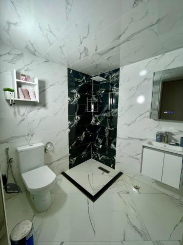 a marble bathroom with a toilet and a sink at Fes Golf Residence in Fez