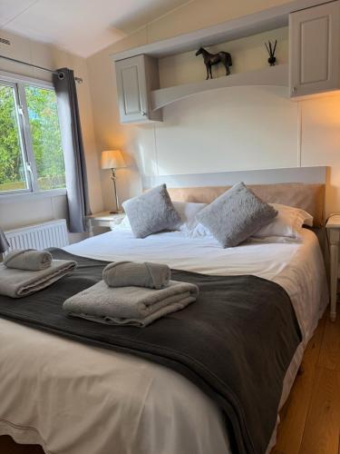 ein Schlafzimmer mit einem großen Bett, auf dem Handtücher liegen in der Unterkunft Eastington in Lapford