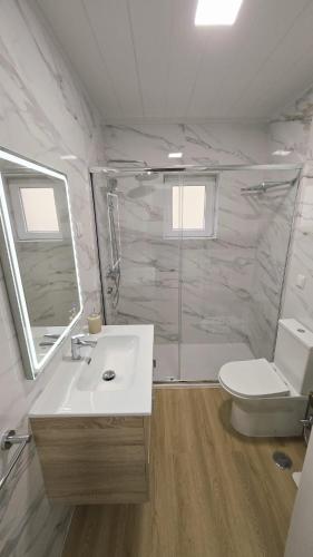 a bathroom with a sink and a toilet and a mirror at Vivenda Prazeres in Sesimbra