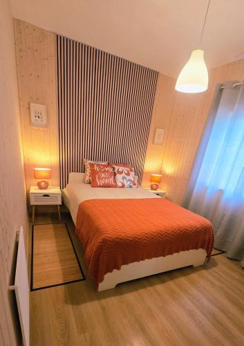 a bedroom with a bed with a orange blanket at Vivenda Prazeres in Sesimbra