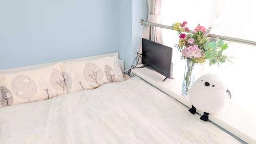 a bedroom with a bed and a vase of flowers at MIYAVI#407 3min walk Narimasu Station, 3 people, double bed & sofa, Tokyo's largest Don Quijote in Tokyo