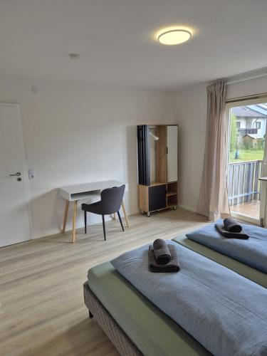 two beds in a room with a desk and a desk at Ferienwohnung KönigSonne in Lauda-Königshofen