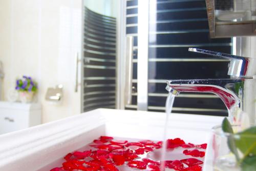 un lavabo lleno de pétalos de rosa roja en Misa Hotel Da Nang, en Da Nang