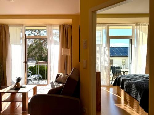 ein Schlafzimmer mit Bett und Blick auf einen Balkon in der Unterkunft Südwind Apartment Nr 05 - FeWo Usedom, strandnah, Schwimmbad, Sauna, Parkplatz, WLAN, und Balkon in Zempin