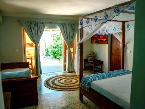 a bedroom with a bed and a door to a yard at Seashore Beach hotel and Bungalow in Kumba Urembo