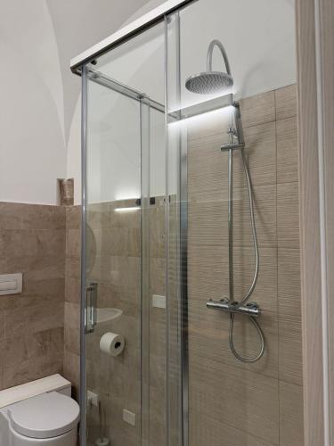 a bathroom with a glass shower with a toilet at Dimora Piazza Palazzo in LʼAquila