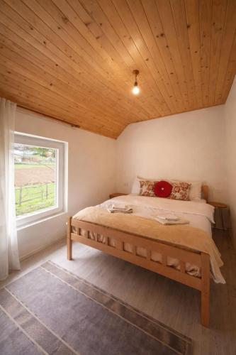 a bedroom with a bed with a wooden ceiling at Ardi Selimaj in Valbonë