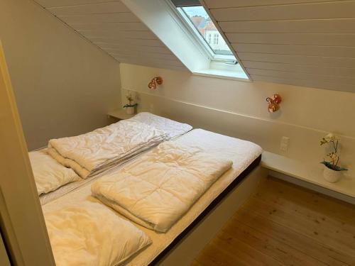 two beds in a room with a window at Panoramaudsigt og swimmingpool midt i Ebeltoft in Ebeltoft