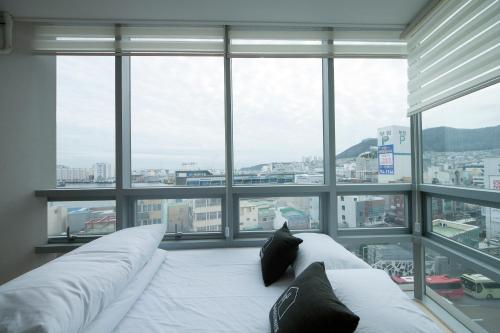 a bed in a room with a large window at K-Guesthouse Premium Nampo 1 in Busan