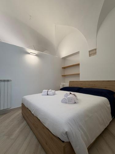 a bedroom with a large bed with towels on it at Dimora Piazza Palazzo in LʼAquila